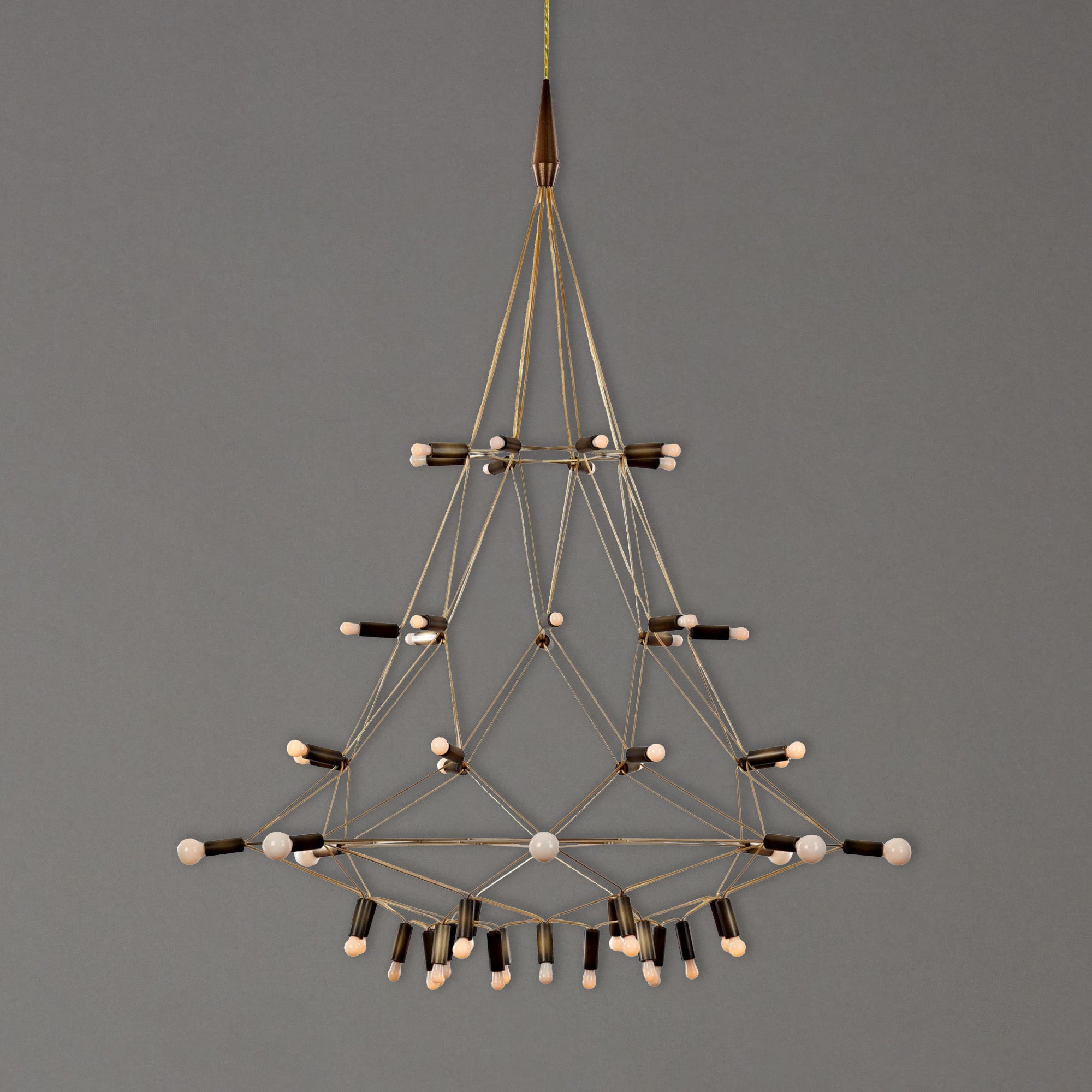 Geometric brass chandelier by Patrick Townsend with multiple bulbs on a gray background